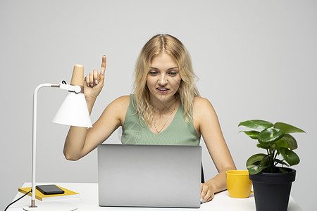 快乐的女子在用笔记本电脑工作时 用一个想法来指着手指 商业计划 启动概念图片