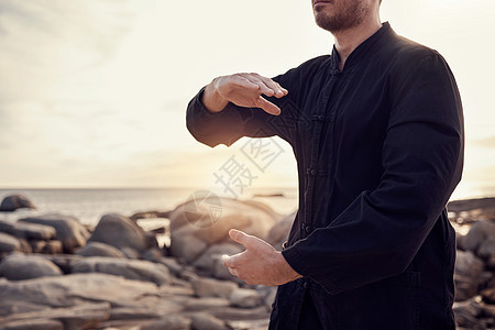 海滩 和平和太极 自然界中的人为了心理健康或控制身心而获得平衡与和平 日落时海上岩石上的精神健康 健身和冥想 能量和自我保健图片