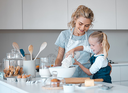 小女孩把面粉倒进碗里 幼儿将面粉筛入碗中 快乐的妈妈帮她的女儿烤面包 白人母亲和她的女儿在厨房里烘焙 一家人一起烘焙图片