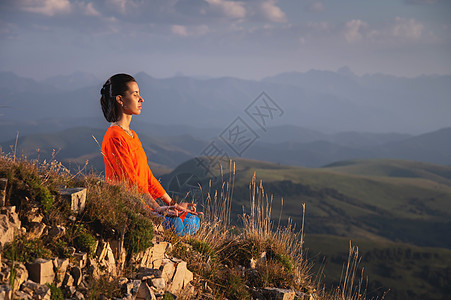 闭着眼睛的冥想女人 在山上穿明亮的衣服 运动服广告横幅图片