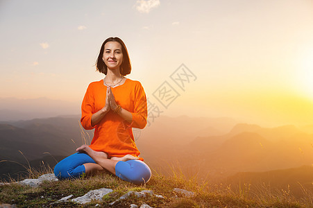 妇女日落时在山上做瑜伽和冥想 一天到晚休息图片