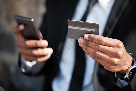 购买您需要的任何东西的最简单方法 一个面目全非的商务人士在城市里使用电话和信用卡图片