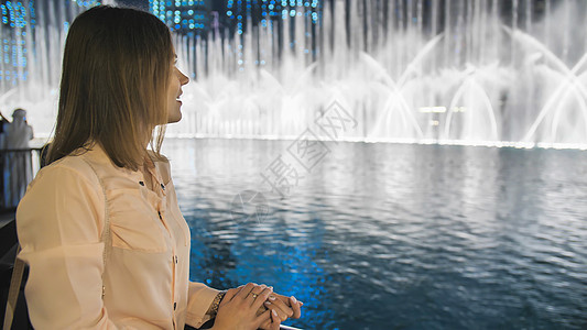 女孩游客晚上在迪拜观赏喷泉 笑声幸福城市旅游村庄投影机景观奢华旅行照明哈里发图片