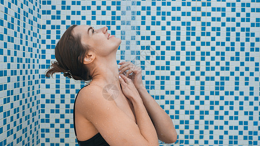 美丽的棕色头发女孩在游泳池游泳后洗个澡微笑黑发洗涤女士卫生护理身体化妆品淋浴浴缸图片