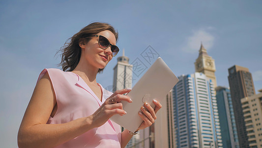一个女孩在一块石板上工作 在大都市摩天大楼的背景之下商务学生管理人员套装技术休息人士工人电脑微笑图片