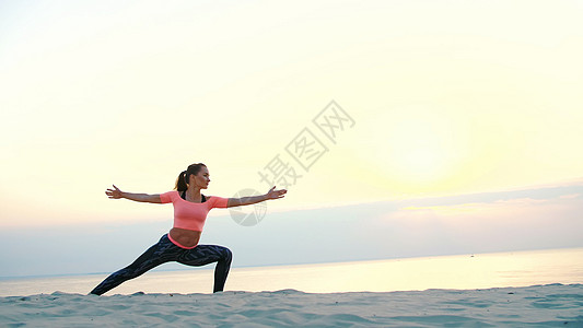 健康 年轻美丽的女人在日出时在海边冥想 练习瑜伽 进行平衡和协调锻炼 深肌张力 特写姿势海滩动作太阳天空专注沉思女性运动日落图片