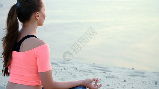 坐在放松瑜伽中的女人在海边的海边摆姿势女性训练平衡日落冥想肌肉身体心情海滩女孩图片