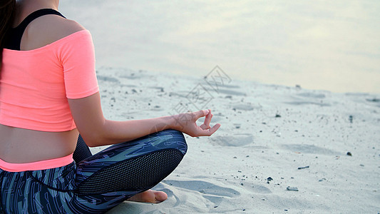 坐在放松瑜伽中的女人在海边的海边摆姿势身体动作女性海滩太阳专注心情运动冥想日落图片