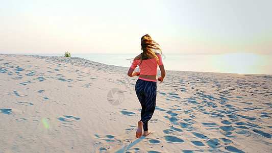 健康 年轻的运动美女沿着沙滩 在沙滩上 在夏天 朝着太阳 在日出时奔跑冥想身体心情专注女孩女士姿势练习训练天空图片