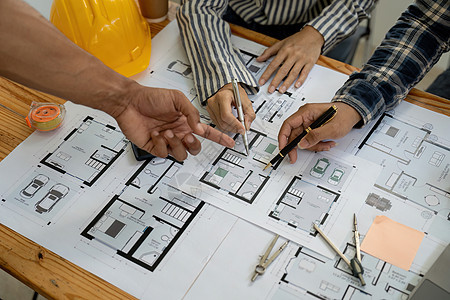 建筑师和工程师团队与建筑规划蓝图合作 工程师草绘建筑项目 绿色能源概念计算机草稿工具房子设计工程男人工作草图设计师图片