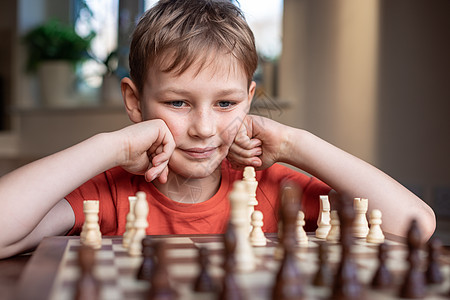 年轻的白人孩子在大棋盘上下棋 小学生面前桌上的棋盘思考下一步爱好闲暇孩子们学习男生逻辑训练教育国王国际图片