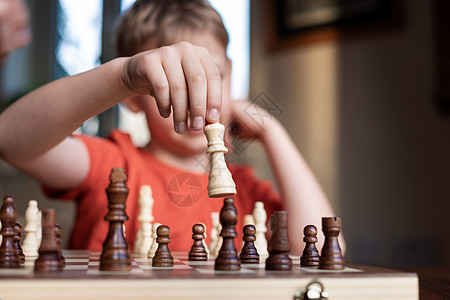 年轻的白人孩子在大棋盘上下棋 小学生面前桌上的棋盘思考下一步活动运动竞赛游戏专注训练骑士爱好学习逻辑图片