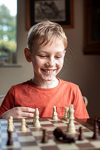 年轻的白人孩子在大棋盘上下棋 小学生面前桌上的棋盘思考下一步活动男生训练思维运动战略竞赛主教数字木板图片