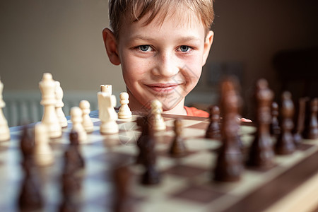 年轻的白人孩子在大棋盘上下棋 小学生面前桌上的棋盘思考下一步爱好专注国际典当教育训练优胜者木板童年竞赛图片