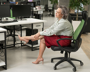白种女人坐在办公室里时用疲劳的腿按摩秘书桌子高跟鞋商务身体椅子痛苦压力疼痛治疗图片