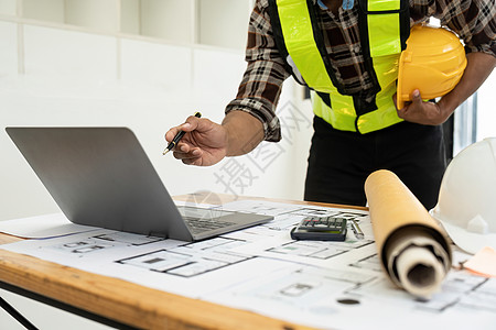 建筑师或工程师使用建筑计划蓝图 工程师草绘建筑项目 绿色能源概念草图职场工作技术绘画商务建造设计师桌子男人图片