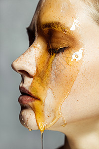 美丽而严肃的黑发美女 长着雀斑 用蜂蜜当面做美容治疗图片