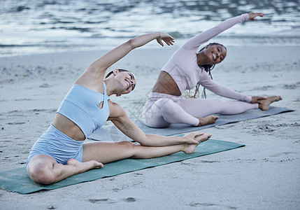 女性朋友 海滩瑜伽和伸展运动以带来微笑 快乐或团队合作以实现健康 保健或平衡 女性团体 早晨和禅宗在海边的正念 以健康锻炼 自我图片