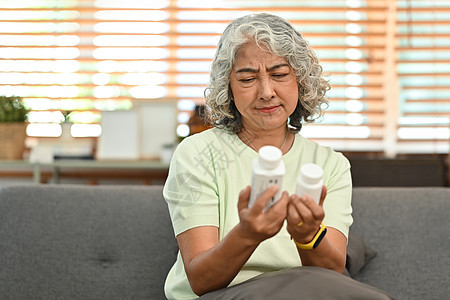 成年女性在吃药前阅读有关包装的医学教育 老年人保健 医药概念 15背景图片