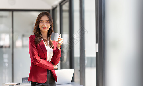女企业家或办公室工作人员站在办公室的桌子附近职场电脑商业团队女士人士公司女性生意人会议图片