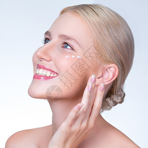 人性化女性将润湿剂奶油膏涂在脸上 以换取完美的皮肤图片