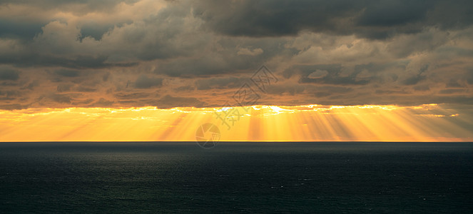 太阳在云层的海面上照耀 以乌云和阳光从他们身上射出图片