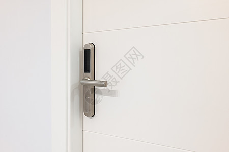 白色门上带复制空间的电子插锁的特写 带显示屏的电子单元内置于金属手柄中 用带有微芯片或数字代码的塑料卡开门图片