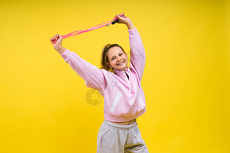 在演播室跳过绳子跳跃的可爱女孩训练女性工作室跳绳微笑快乐运动装绳索孩子白色图片
