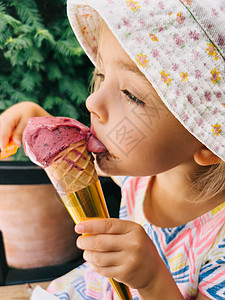小女孩舔一个冰棒 在甜筒里 握在她手里图片