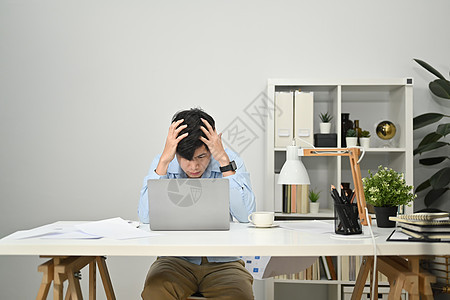 沮丧的商务人士头疼 因过度劳累或工作压力而疲惫不堪图片