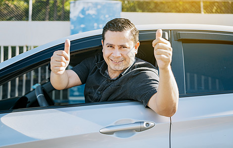 快乐的司机在路上竖起大拇指 安全驾驶理念 满意的司机人现身拇指 车里的年轻司机竖起大拇指图片