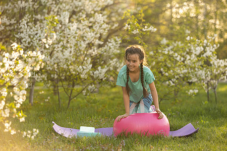 一个小女孩做瑜伽 躺在公园体育垫子上 健康的生活方式是一种幼稚习惯 笑声运动夫妻童年冥想草地生活活力后院训练喜悦图片