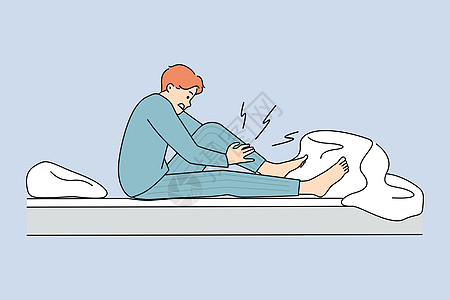 床上看手机躺在床上的不健康男人腿抽筋设计图片