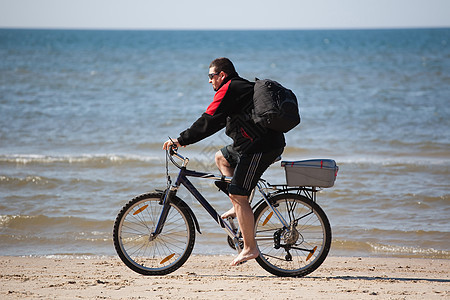 男子骑山上自行车在海滩上 海洋 自然 旅行图片
