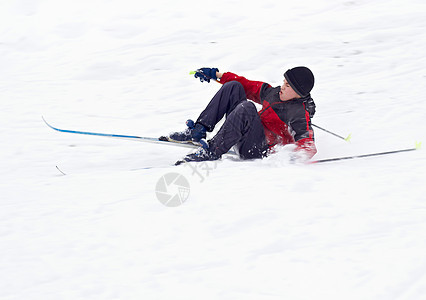 男孩滑雪落在雪上图片