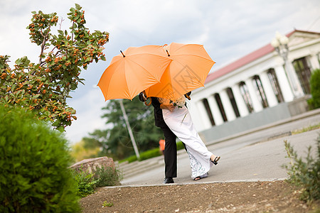 带橙色雨伞的新娘和新郎 爱 已婚 城市 热情 街道图片