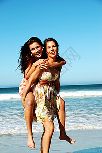 两个年轻女人夏天在沙滩上玩得开心 漂亮的 乐趣图片