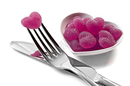 粉红心形果冻糖果 用刀和叉子在白色上图片