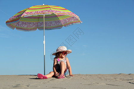 有太阳眼镜的小女孩 坐在阳光罩下图片