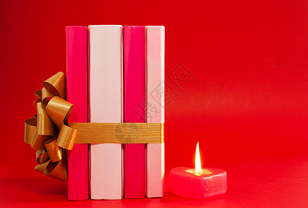 挂着丝带和烧蜡烛的一排书 图书 情人节 礼物 弓图片