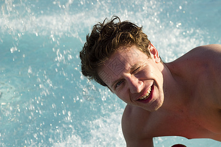 在游泳池中快乐的男子 与水泼水 太阳 放松 男性背景图片