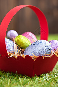 带巧克力复活节鸡蛋的红篮子 草地 手工制作 鲜艳的色彩 棕色的图片