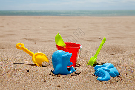 彩色塑料沙滩玩具 假期 齿轮 桶 海背景图片