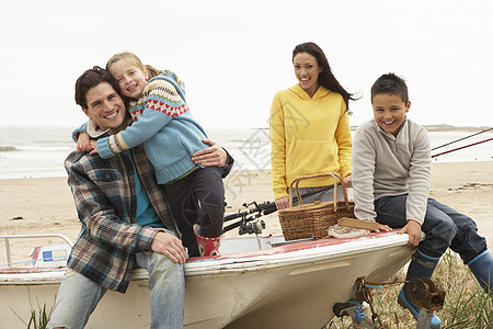 家庭小组在冬季海滩与钓鱼 Rod号船上坐船 父亲 杆图片
