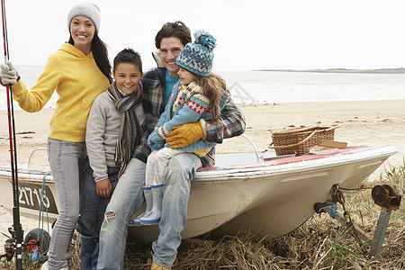 家庭小组在冬季海滩与钓鱼 Rod号船上坐船 男生 笑声图片