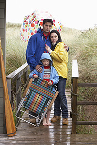 带雨伞的海滩上家庭 男性 沉淀 三十多岁 女士 天 毁坏图片