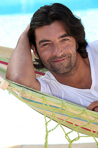 人坐在吊床上的海滩上图片