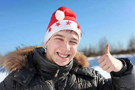 戴着圣塔帽的年轻人 大拇指 冬天 帽子 外套图片