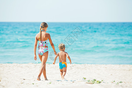 年轻女孩和男孩在美丽的海滩上快乐地玩耍 绿松石图片