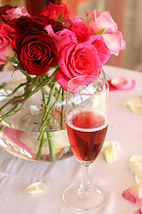 盛满玫瑰和香槟的一团花束和一杯香槟图片